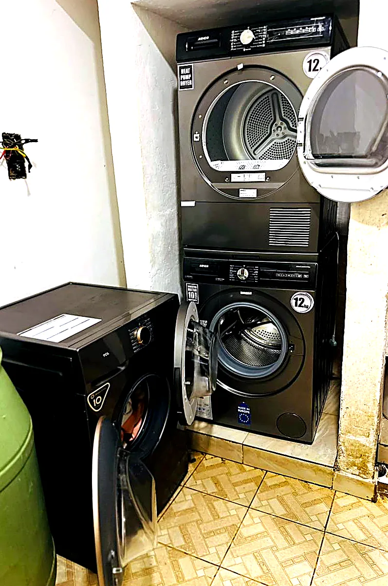 Modern stacked dryer and washing machine with door open, ready to load